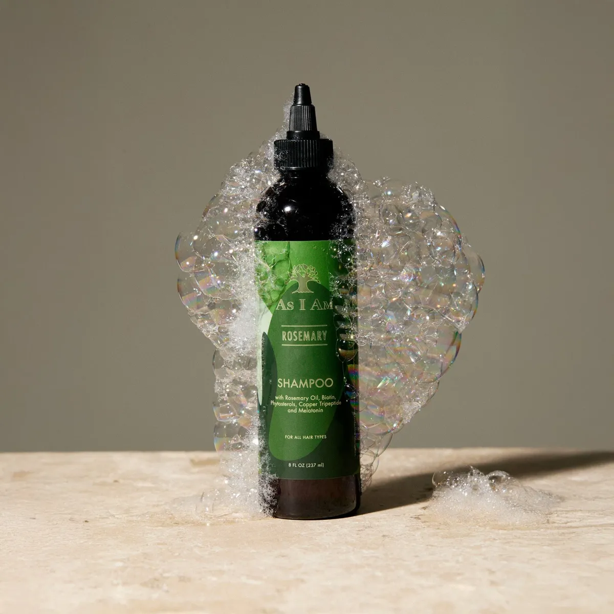 As I Am Rosemary Shampoo bottle surrounded by foam